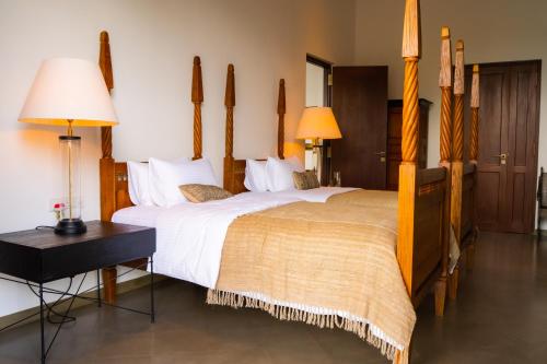 a hotel room with two beds and two lamps at Lily Pod in Panadura