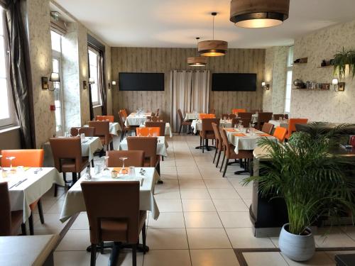 a restaurant dining room with tables and chairs at Logis Hotel Beaudon in Pierrefonds