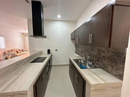 a kitchen with wooden cabinets and a sink at Departamento isla central 2 in Mazatlán