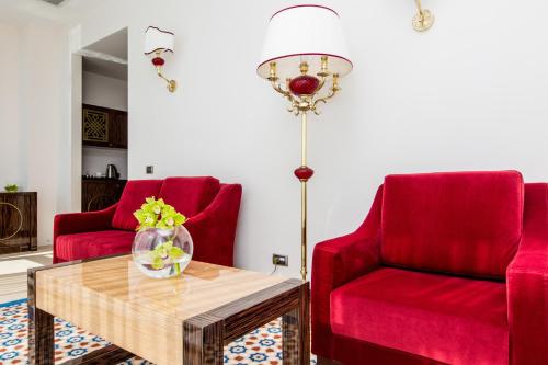a living room with two red chairs and a table at KADORR Hotel Resort & Spa in Odesa