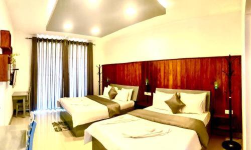 um quarto de hotel com duas camas num quarto em White City Villa em Nuwara Eliya