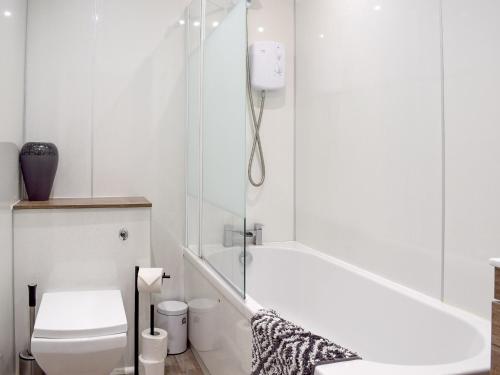 a white bathroom with a toilet and a shower at The Hideaway in Crieff