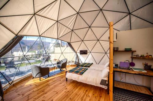 Kaynaşlı的住宿－Nandu Dogal Yasam Ciftligi，一间卧室设有一张带床和椅子的大帐篷