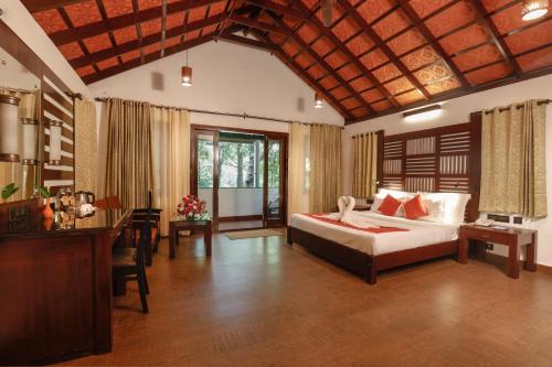 a bedroom with a bed and a desk in a room at Vythiri Resort in Vythiri