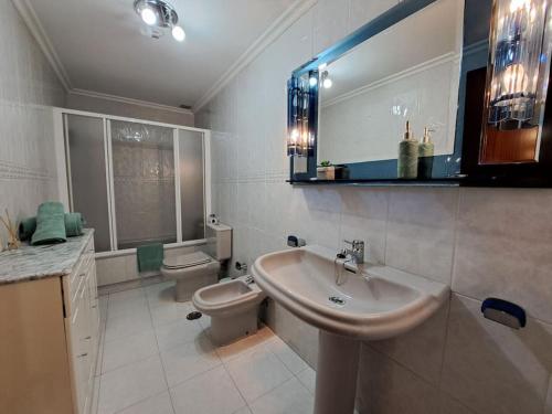 a bathroom with a sink and a toilet at Baiona, primera línea de Playa Ladeira, terraza. in Baiona