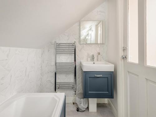 Skye House في بيكويل: حمام مع خزانة زرقاء ومغسلة