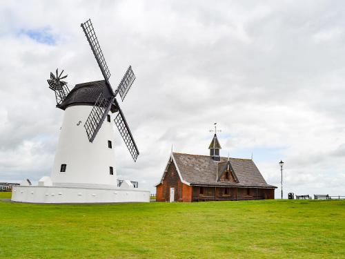 a windmill in a field next to a building at Clifton House B - Uk42844 in Lytham St Annes