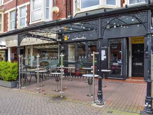 a group of tables and chairs in front of a store at Clifton House B - Uk42844 in Lytham St Annes