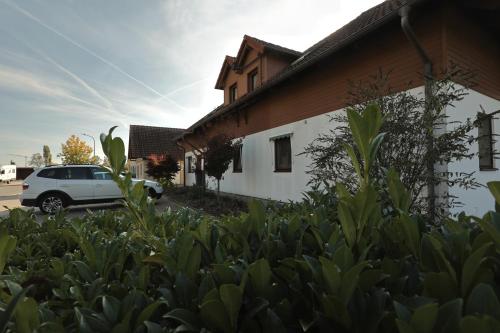 a white car parked in front of a building at Pension Zum Paradies in Harthausen