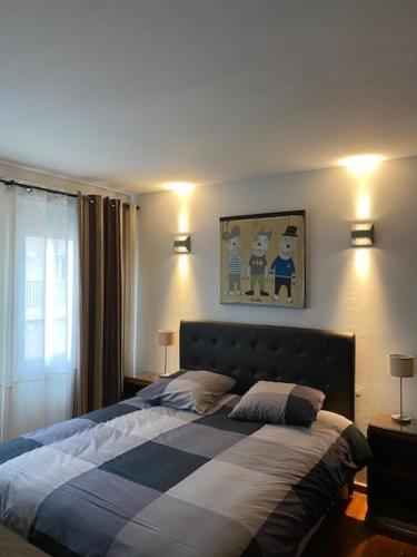 Le Patio Père Pigne Guestroom في بيربينيا: غرفة نوم بسرير وبطانية زرقاء وبيضاء