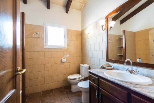 a bathroom with a sink and a toilet and a mirror at Jomar in Cala en Bosc