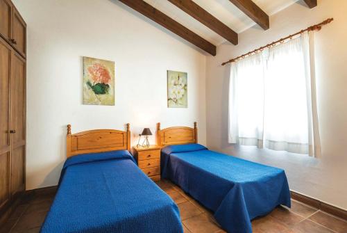a bedroom with two beds and a window at Jomar in Cala en Bosc