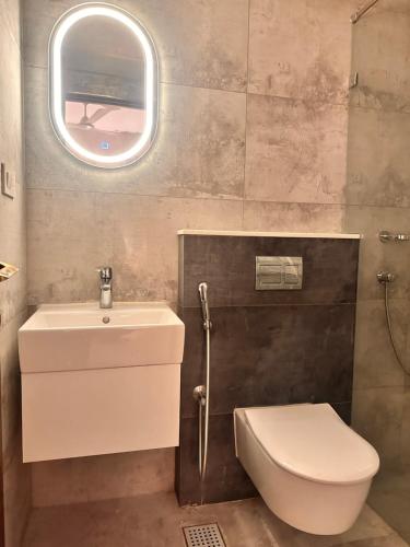 La salle de bains est pourvue de toilettes, d'un lavabo et d'une fenêtre. dans l'établissement Celesto Luxury Residences by Chakola’s Hospitality, à Thrissur