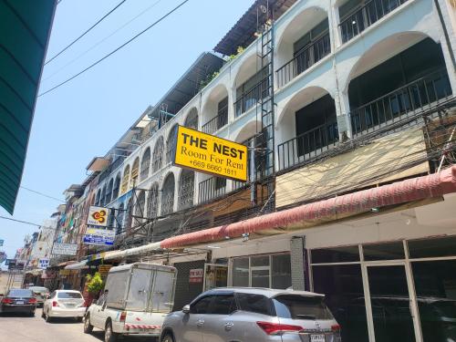 a sign that reads the nest next to a building at THE NEST in Pattaya