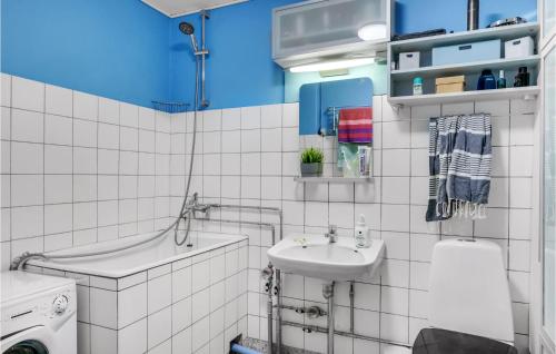 a white tiled bathroom with a sink and a tub at 1 Bedroom Amazing Apartment In Kbenhavn Sv in Copenhagen