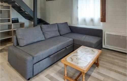 a gray couch in a living room with a table at Lovely Home In Sainte Croix-Volvestre in Montberaud