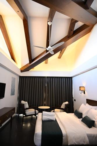 a bedroom with a bed and a ceiling fan at Vee Resort- The Suites of Royals in Mahabaleshwar
