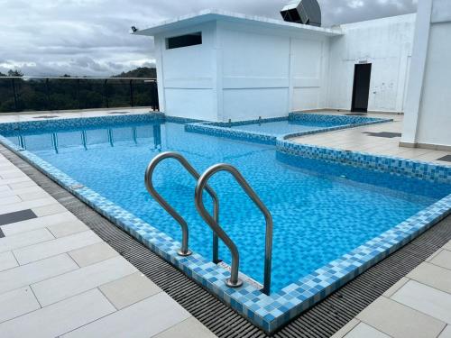 グア・ムサンにあるHASSMA Studio Apartment with Poolの大型スイミングプール(水中の2つのハンドル付)