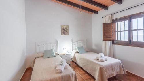 a room with two beds with towels on them at Casa Elena de Benagalbon Rincon de la Victoria by Ruralidays in Rincón de la Victoria