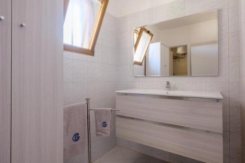 a white bathroom with a sink and a mirror at Villa Esperanza Torre Specchia in Torre Specchia Ruggeri
