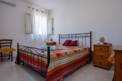 a bedroom with a bed with a colorful blanket at Villa Esperanza Torre Specchia in Torre Specchia Ruggeri