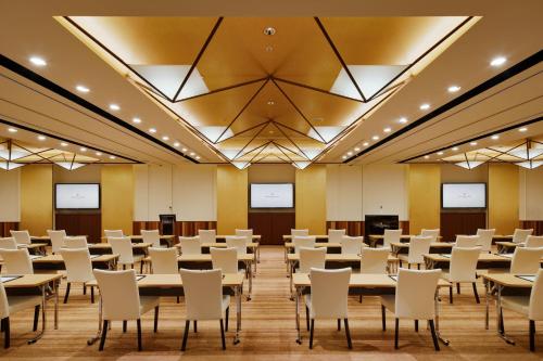 a conference room with tables and white chairs at InterContinental Hotel Osaka by IHG in Osaka