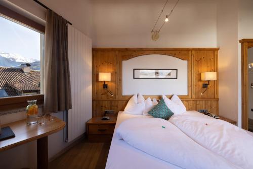 a hotel room with two beds and a window at Hotel Patriarch in Tirolo