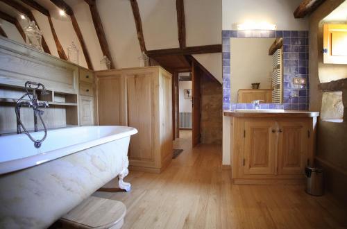 uma grande casa de banho com banheira e lavatório em Maison des Sarrasins em Beynac-et-Cazenac