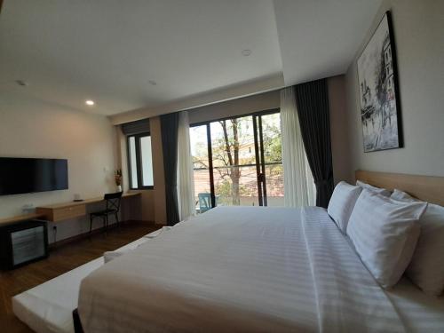 a bedroom with a large white bed and a large window at Happy Home in Nha Trang