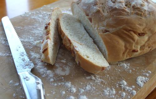 a sandwich on a cutting board next to a knife at Embleton Spa Hotel & Apartments in Embleton