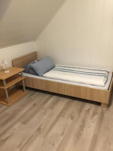 a bed in a room with a wooden table at Ferienwohnung Heigemeir in Ehekirchen
