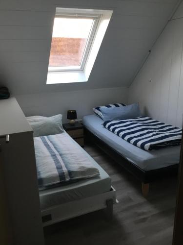 two beds in a small room with a window at Ferienwohnung Familie Heigemeir in Ehekirchen