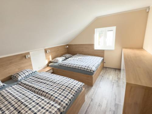 two beds are in a room with a attic at Dům v Beskydech – Trojanovice in Trojanovice