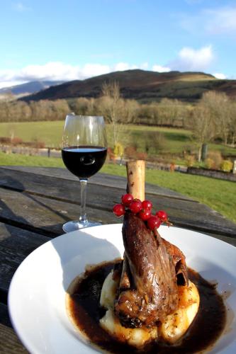 a plate of meat and a glass of wine at Embleton Spa Hotel & Apartments in Embleton