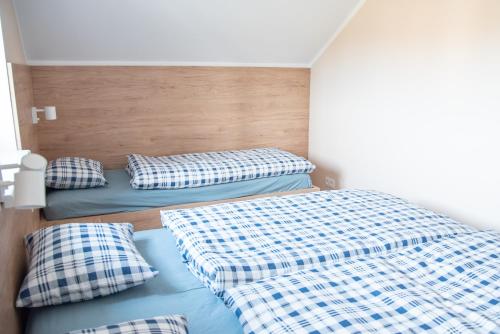 two beds in a room with plaid pillows at Dům v Beskydech – Trojanovice in Trojanovice