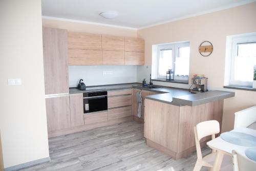 a kitchen with wooden cabinets and a counter top at Dům v Beskydech – Trojanovice in Trojanovice