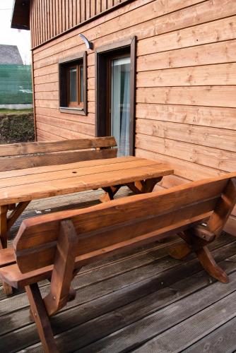 a wooden bench sitting on top of a wooden deck at Dům v Beskydech – Trojanovice in Trojanovice
