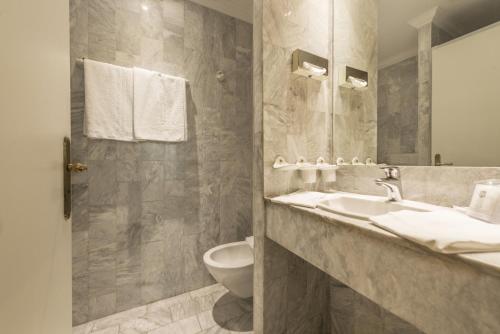 a bathroom with a sink and a toilet at Ambassador-Monaco in Monte Carlo