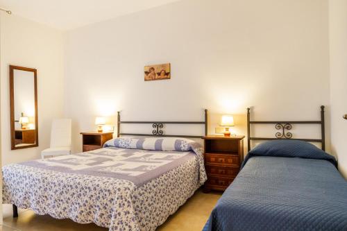 a bedroom with two beds and a mirror at Casa Rita in Castiglione della Pescaia