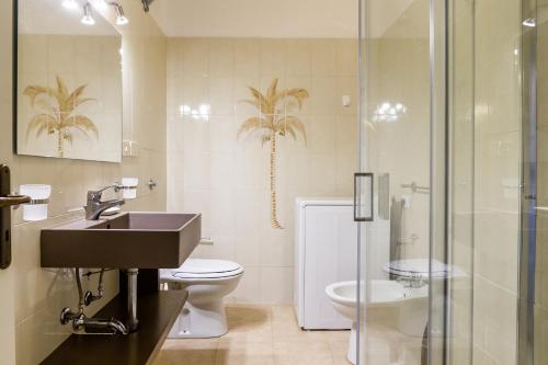 a bathroom with a sink and a toilet and a shower at Casa Rita in Castiglione della Pescaia