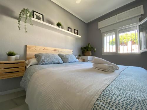 a bedroom with a large bed and two windows at PINAR 10 in Chiclana de la Frontera