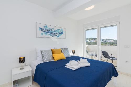 una camera bianca con un letto blu e asciugamani di Vila Nena a Vodice