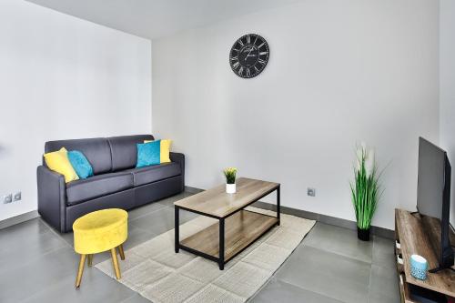 un salon avec un canapé et une table dans l'établissement Appartement Le Spacieux Lyonnais, à Villeurbanne