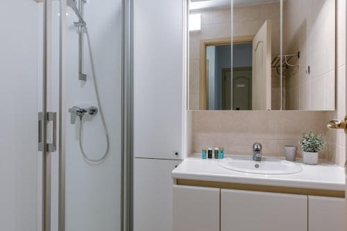 ein Bad mit einer Dusche und einem Waschbecken in der Unterkunft Bright apartment with beautiful sea view in Middelkerke