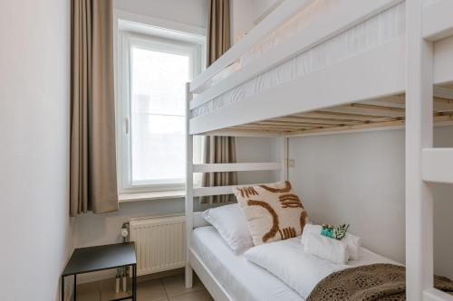 Ce lit superposé blanc se trouve dans une petite chambre dotée de lits superposés. dans l'établissement Bright apartment with beautiful sea view, à Middelkerke