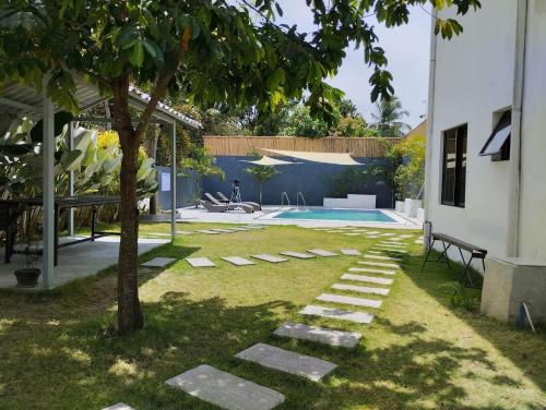 einen Garten mit einem Baum und einem Pool in der Unterkunft Casa LeoMa in Cavite