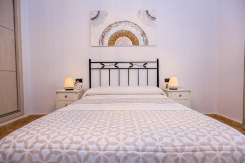 a white bedroom with a large bed with two night stands at Villa Albada - ONLY FAMILIES in Miami Platja