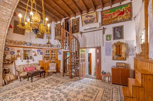 een woonkamer met een kroonluchter en een trap in een huis bij Beautiful historic house in Koskinou