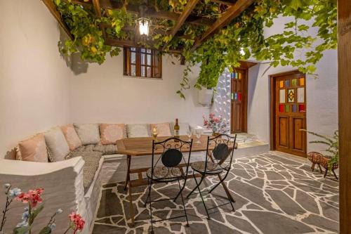 a living room with a couch and a table and chairs at Beautiful historic house in Koskinou