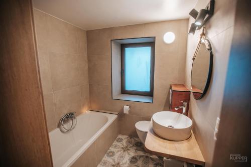 a bathroom with a tub and a toilet and a sink at Le vieux Sanglier - 41 pers - Malmedy in Malmedy